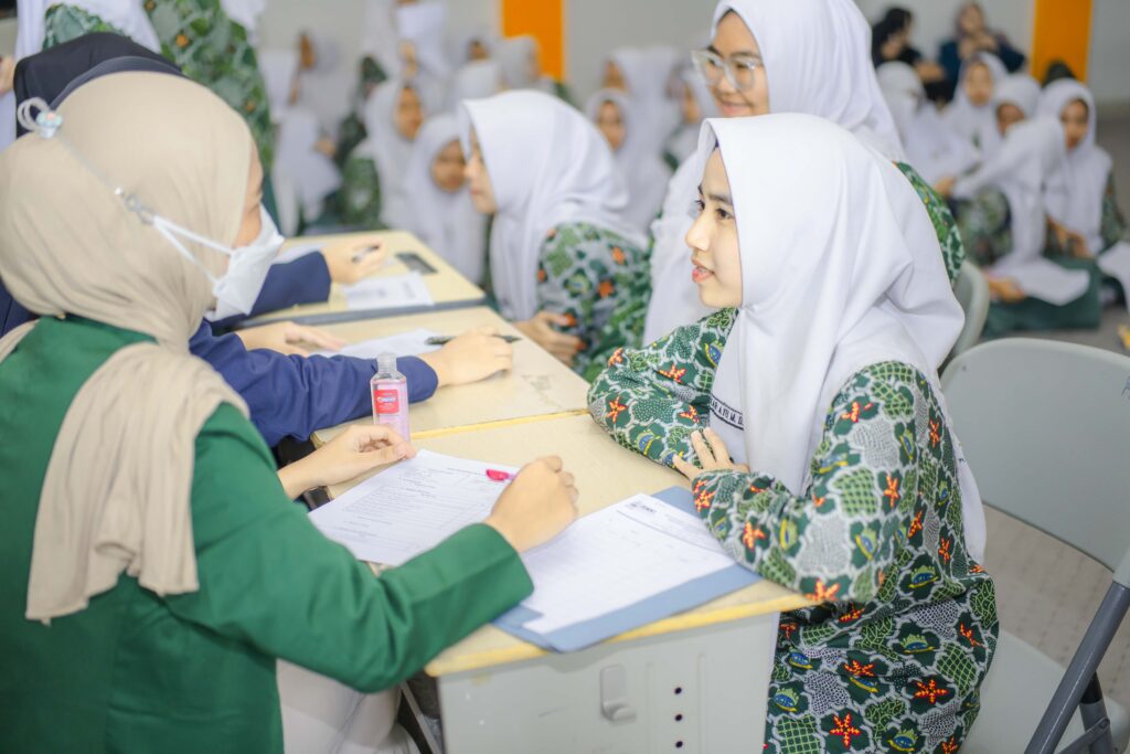 Siswa SMA Progresif Bumi Shalawat sedang melakukan pemeriksaan dengan mahasiswa ISMKI